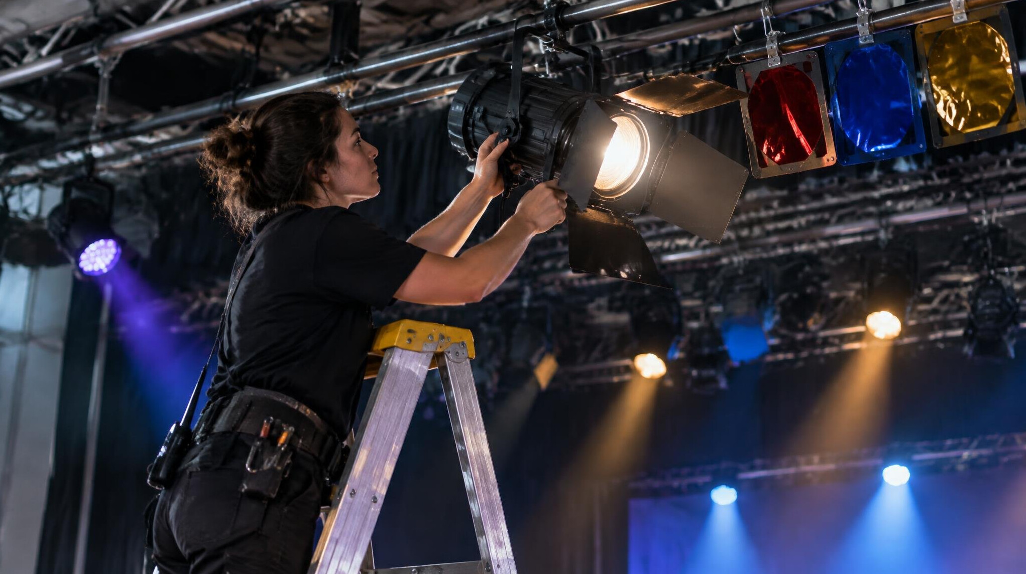 British lighting technician adjusting a stage spotlight